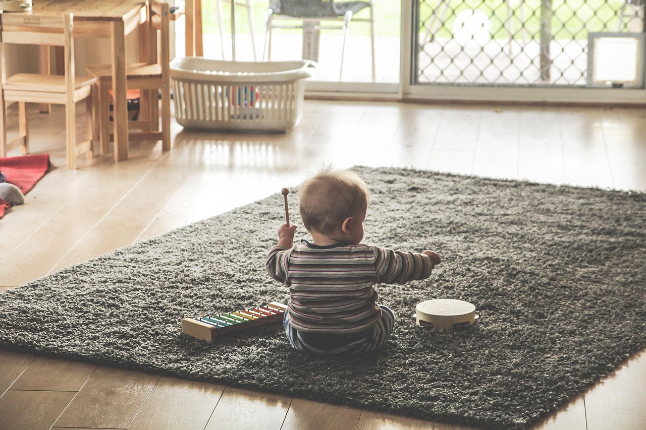 Child playing independently at home near everyday household items