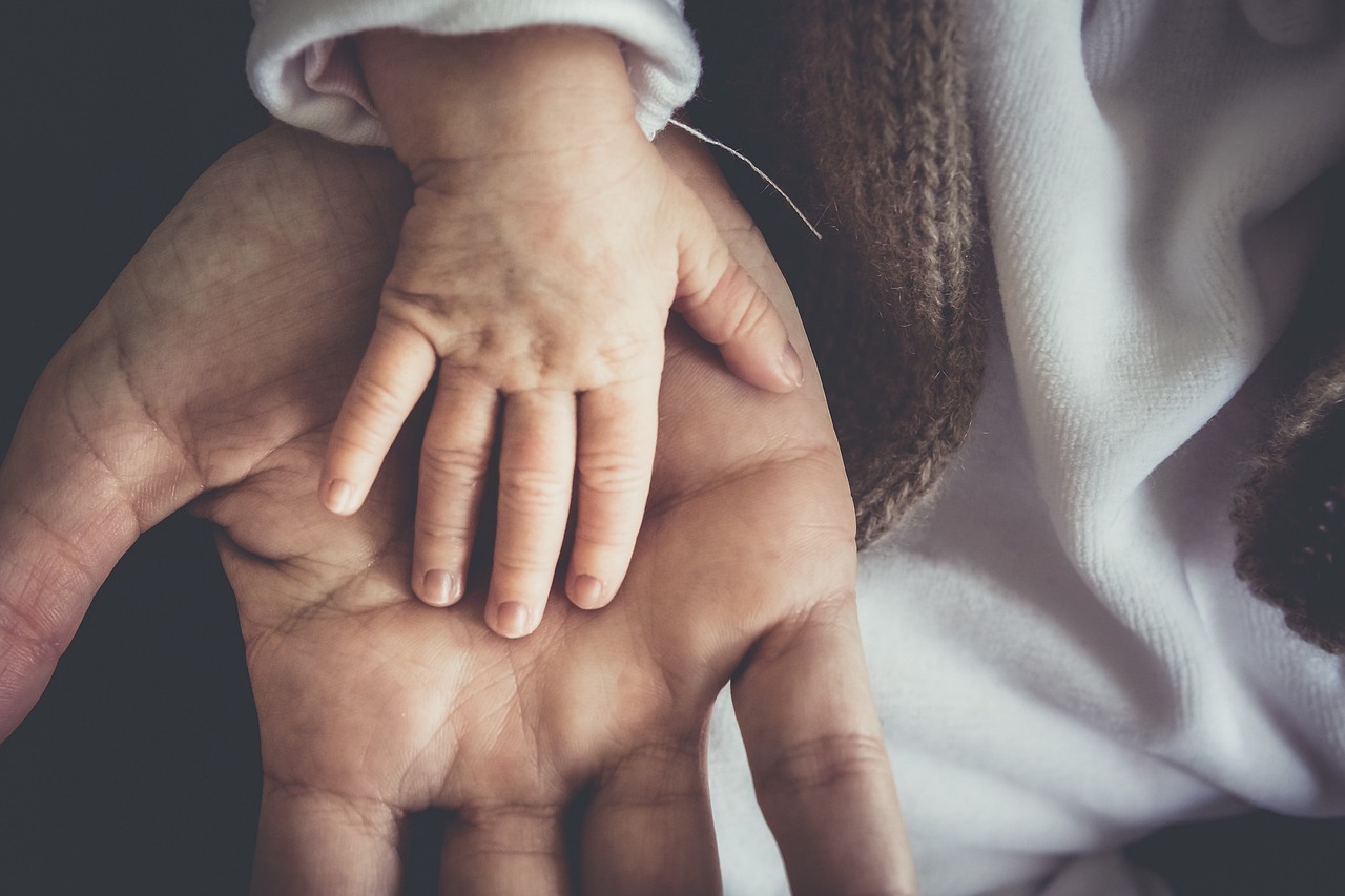 Child's hand resting in a caregiver's open hand