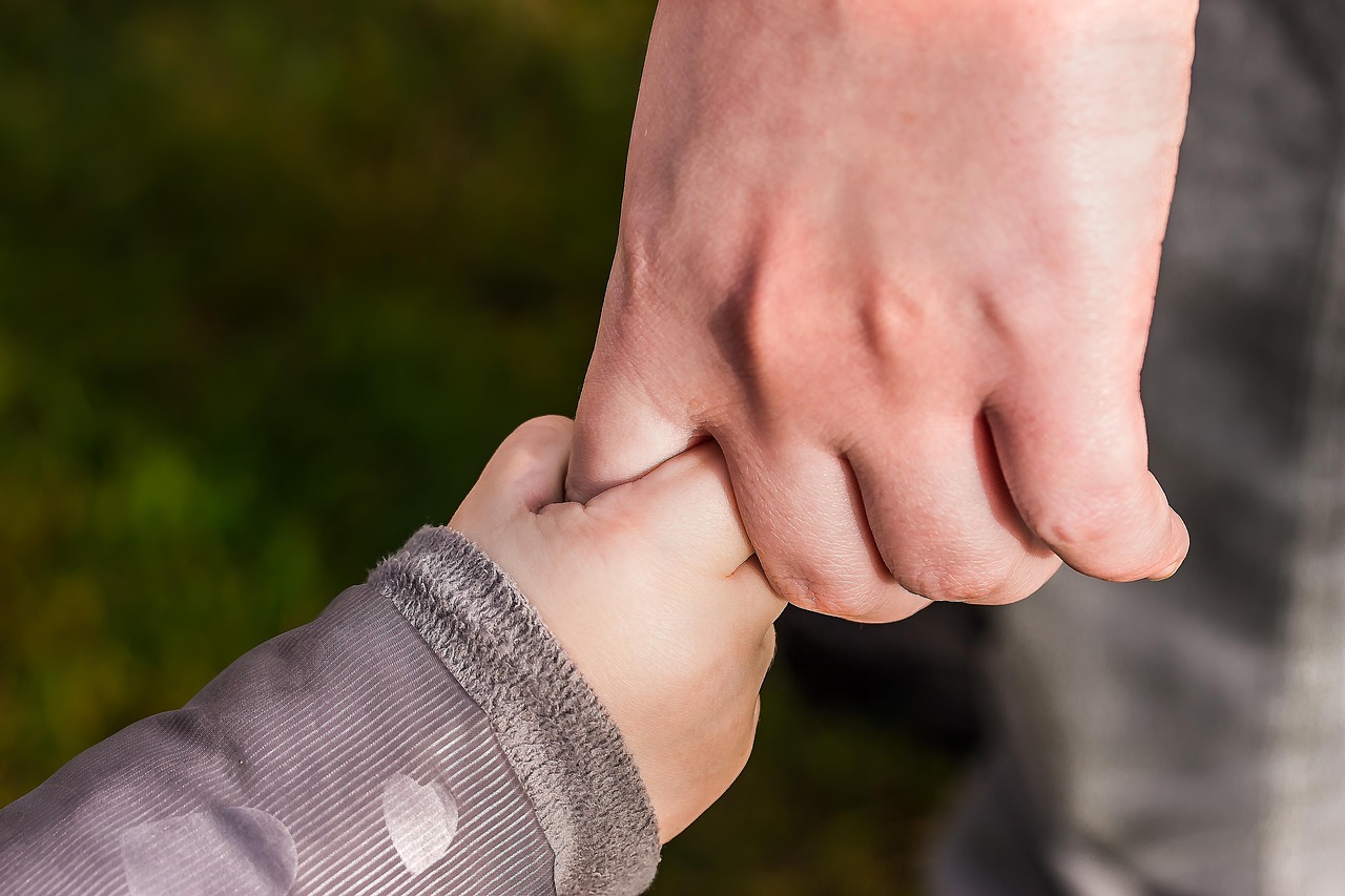 Parent and child holding hands together